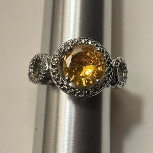 Round Cut Yellow Stone Ring with ornate halo in silver tone circular setting
